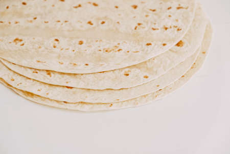 Thin pita bread on a white wooden table background.の写真素材