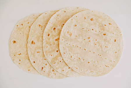 Thin pita bread on a white wooden table background.の写真素材