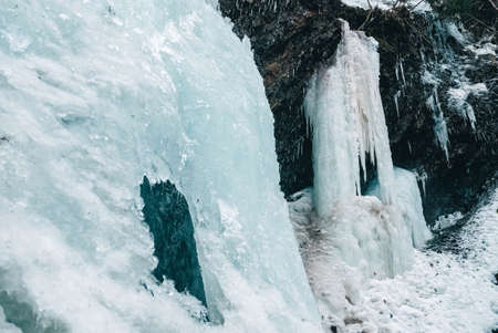 Winter waterfall with frozen water and snow.の写真素材