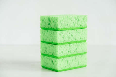 Green sponges for cleaning on a white background.の写真素材