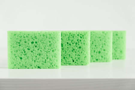 Green sponges for cleaning on a white background.の写真素材