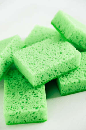 Green sponges for cleaning on a white background.の写真素材