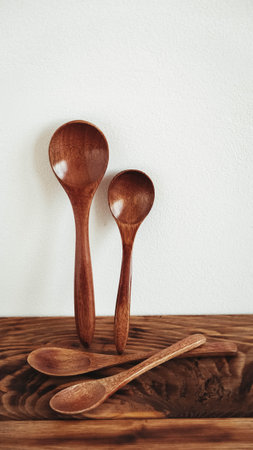 Wooden spoons from dark wood on a wooden table background.の写真素材