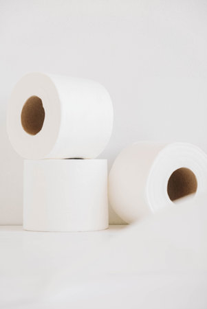 Rolls of white toilet paper on a white background.