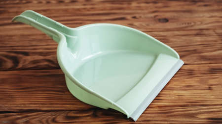 Plastic garbage scoop on a wooden background.の写真素材