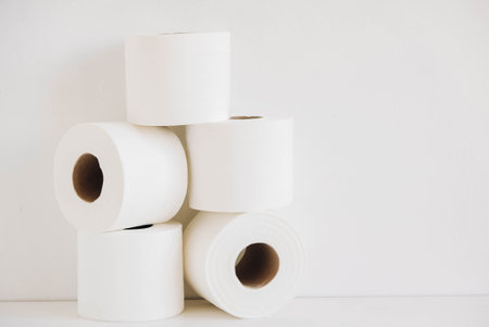 Rolls of white toilet paper on a white background.