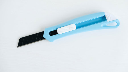 Stationery knife in blue on a white background.