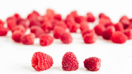 Fresh red raspberries on a white table background.の写真素材