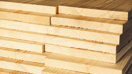 Stacked wooden carpentry boards from natural wood in a woodworking industry.の写真素材