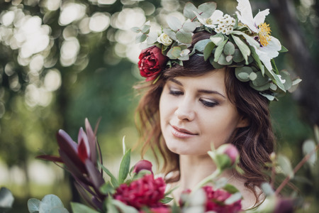 Portrait of young beautiful girl with flowers in circlet of flowersの写真素材