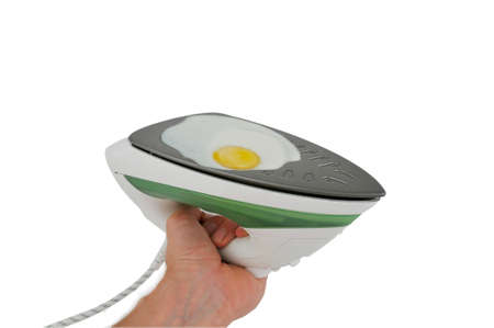 Fried eggs in electric iron. Concept original ideaの写真素材