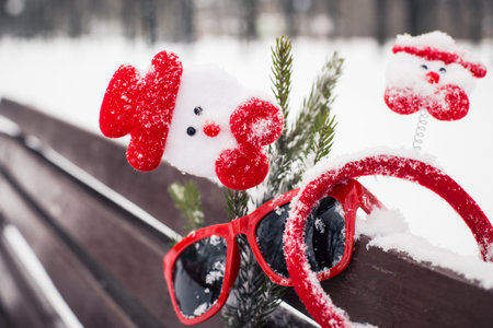 Funny winter composition with christmas accessories, red sunglasses and a fragment of a pine-tree...