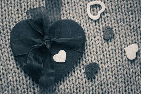 A big felt heart and  small hearts with wool texture in the background. Black and whiteの写真素材