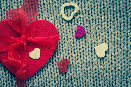 Red felt heart and  colorful decorative  hearts with wool texture in the background. Valentine's day theme. Toned effectの写真素材