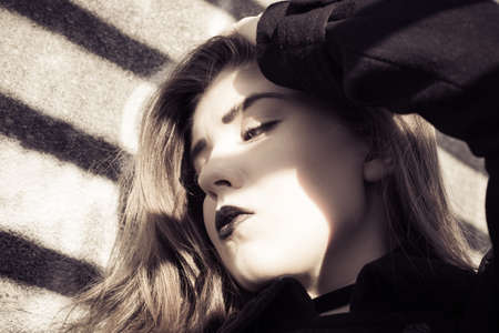 Portrait in profile of a beautiful teenage girl with black lipstick close up. Toned effectの写真素材