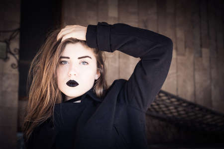 Portrait of a pretty teenage girl with black lipstick. Toned effectの写真素材
