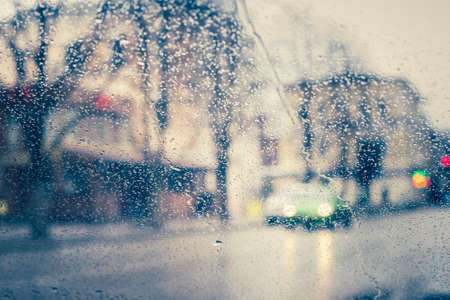 City road seen through  water drops on the car windshieldの写真素材