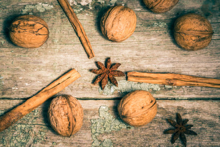 Star anise, cinnamon sticks and walnuts on an old painted wooden background. Winter composition