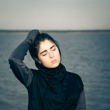 Portrait outdoor of a hipster teenage girl with eyes closed. Toned effectの写真素材