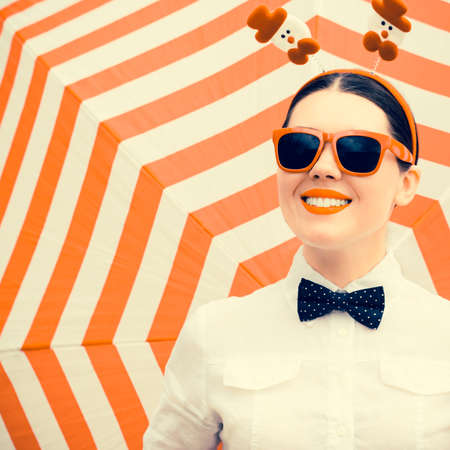 Portrait of a smiling girl in Christmas outfit  next to a striped backgroundの写真素材