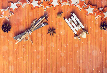 Winter composition with star anise, acorn, pine cone, colorful felt stars, decorative sledge and ski on the wooden background. Top viewの写真素材