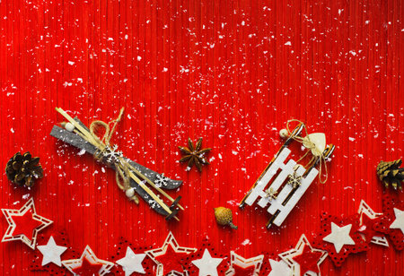 Winter composition with star anise, acorn, pine cone, colorful felt stars, decorative sledge and ski...