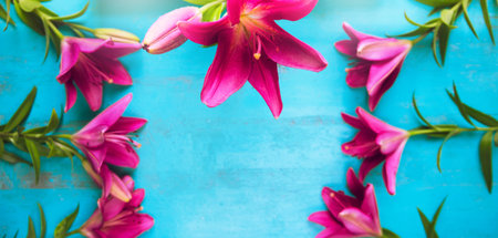 Fresh garden lilies lying as a frame on old painted wooden table. Beautiful floral background for...
