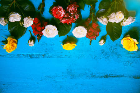 Colorful flowers on old painted wooden table. Summer floral background.の写真素材