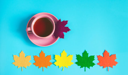 Cup of tea with decorative felt maple leaves. Top view. Autumn concept backgroundの写真素材