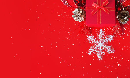 Decorative white snowflake, red present box, golden cones and shiny derative balls as a festive...