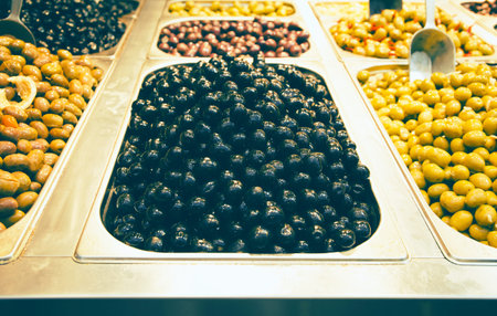 Olives in bowls at the market for sale. Traditional mediterranean food suitable for vegans and...