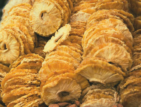 Slices of dried pineapple at the market close up. Tasty  snack suitable for vegeterians and vegans. Food concept backgroundの写真素材