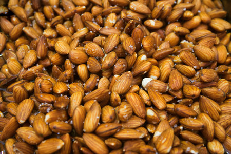 Peeled almond nuts with salt at the market close up. Selective focus. Healthy food concept...