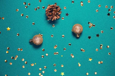 Golden decorative balls, cone and sequins on bright background. Christmas backdrop. Celebration and...