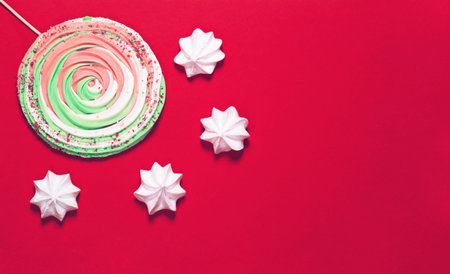 Colorful  meringues on red background. Festive and party concept. Minimal style. Flat lay. Top view....