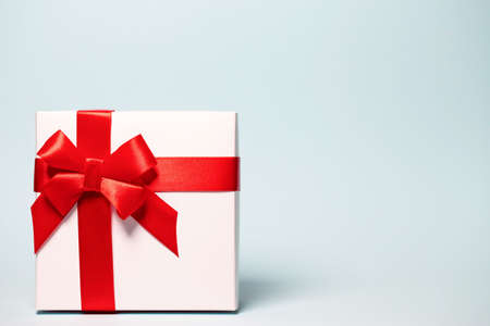 Present box  wrapped with red ribbon on colorful background. Festive and holiday theme. Christmas or birthday gift. Sales and shopping concept.の写真素材