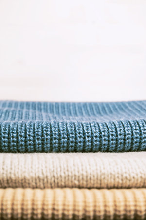 Stack of knitted  sweaters. Fall and winter season knitwear. Warm clothes concept. Copy space