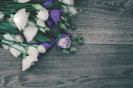 Bouquet of eustoma flowers on wooden table. Beautiful spring background for seasonal cards, posters,...