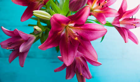 Bouquet of beautiful fresh garden lilies close up on old painted wooden table. Floral background.の写真素材