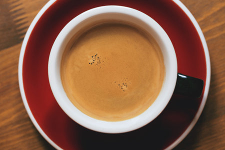 A cup of coffee close up on wooden table as a background. Flat lay style. Top view