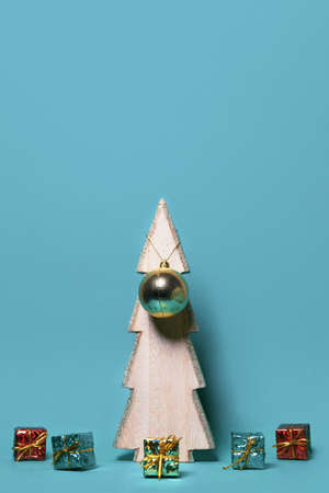 Decorative present boxes on green paper background with decorative christmas tree and pine cones. Celebration and holiday concept. Top view. Image is with copy spaceの写真素材