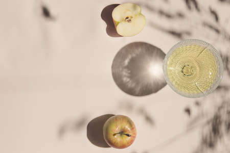 Summer still life composition made of apples and glass on pastel background white cloth. Creative layout. Freshness concept. Top view. Flat lay. Copy spaceの写真素材