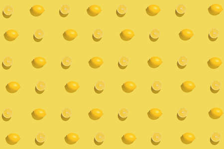 Creative pattern made with sliced fresh lemon on yellow background. Summer fruit concept. Minimal style. Sunlit flat lay. Top viewの写真素材