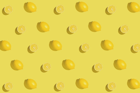 Creative pattern made with sliced fresh lemon on yellow background. Summer fruit concept. Minimal...