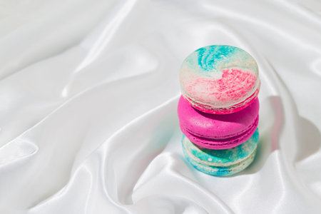 Creative background made with macaroons and white silk sheet. Minimal style composition.