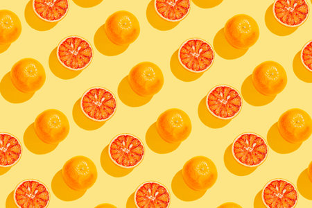 Creative pattern made with blood orange on yellow background. Summer fruit concept. Minimal style....