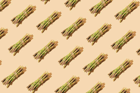 Creative pattern made of green asparagus. Food suitable for vegans and vegetarians. Healthy cooking concept. Minimal style. Top view. Flat layの写真素材