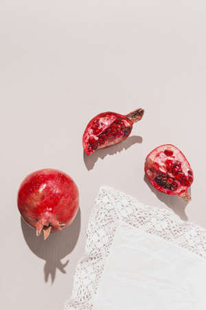 Fresh pomegranates on pastel gray background with white fabric. Minimal style. Top view. Flat layの写真素材