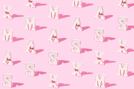 Creative pattern made of white xmas letters on pastel pink background. Minimal style. Christmas celebration concept.の写真素材