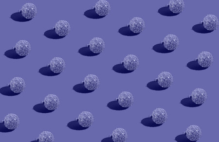 Simple pattern made of golden baubles on lavender background. Creative winter composition. Christmas...